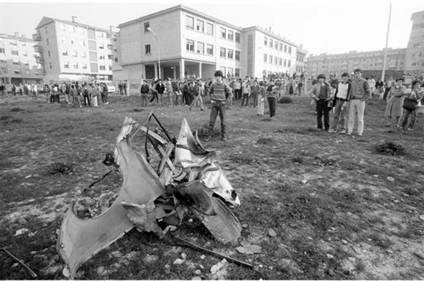 Pamplona, 1984. Varios escolares contemplan los restos del coche bomba que acaba de hacer explosión junto a su colegio. En el atentado murieron dos policías: Juan José Visiedo y Tomás Palacín. La relativa perplejidad de los jóvenes es el resumen de una época que ahora parece llegar a su fin.